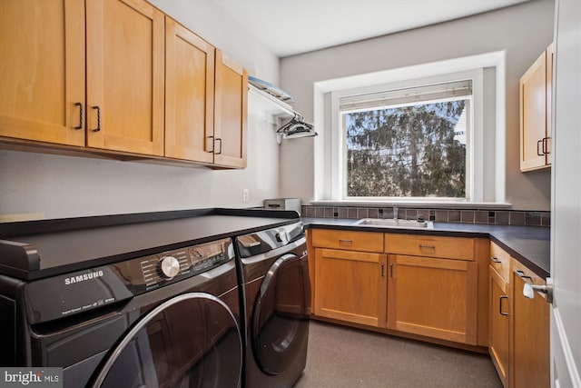 washroom with washer and dryer, cabinet space, and a sink