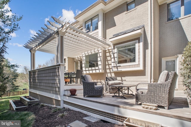 back of property featuring brick siding, a wooden deck, and a pergola