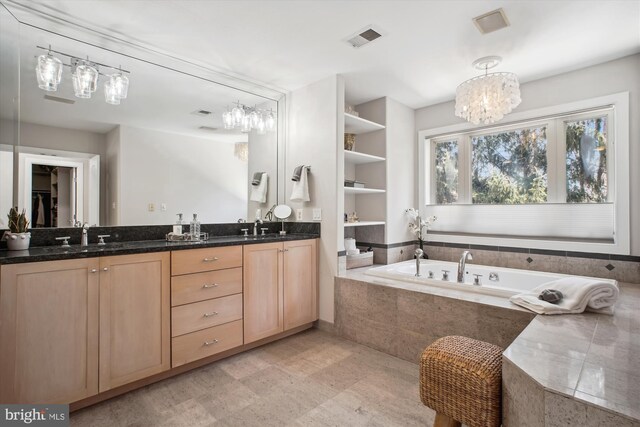 full bathroom with a bath, an inviting chandelier, visible vents, and a sink