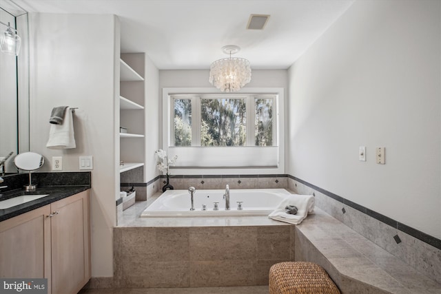 bathroom featuring a garden tub, a notable chandelier, vanity, and visible vents