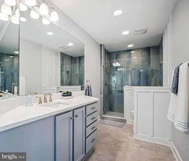 full bathroom with vanity, toilet, a stall shower, and recessed lighting