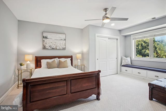 bedroom featuring a closet, ceiling fan, visible vents, and light carpet