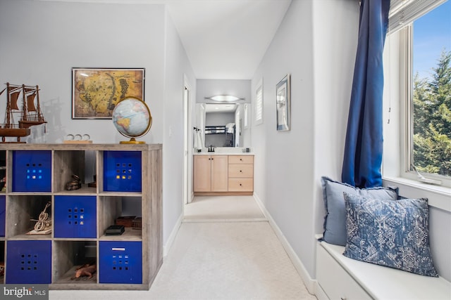 hallway with baseboards and a sink