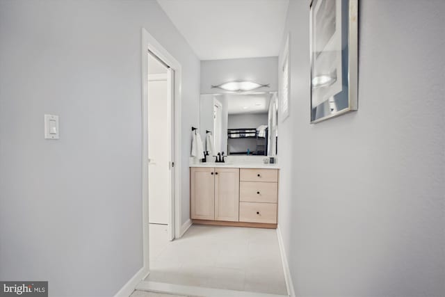 hall with baseboards and a sink