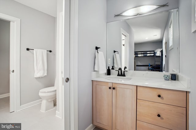 bathroom featuring toilet, vanity, and baseboards