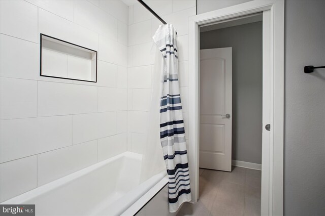 full bathroom featuring shower / tub combo and baseboards