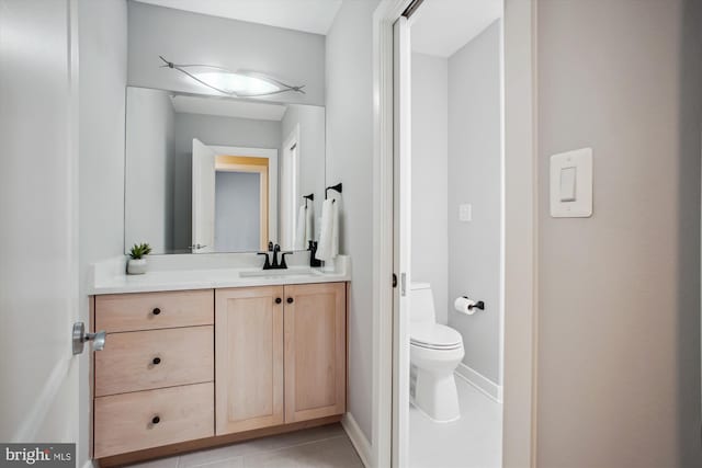bathroom featuring tile patterned flooring, baseboards, toilet, and vanity