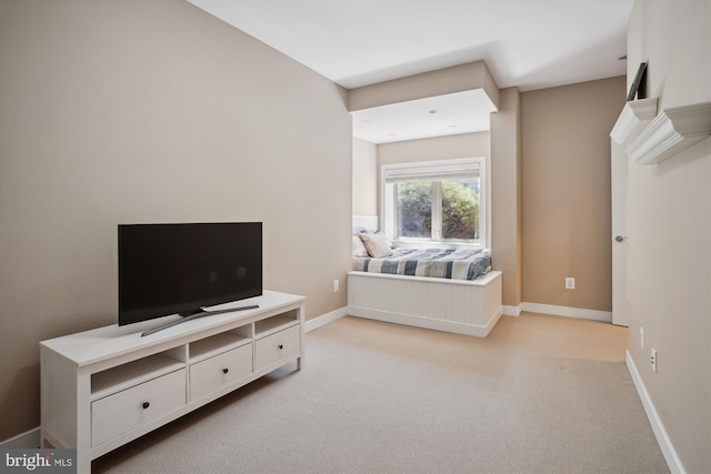 bedroom featuring light carpet and baseboards