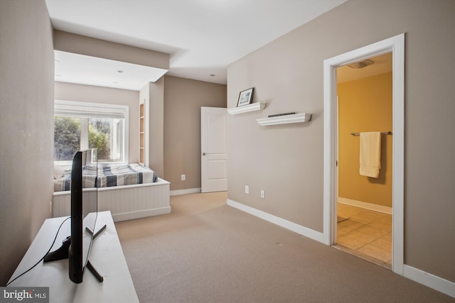 carpeted bedroom featuring baseboards and connected bathroom