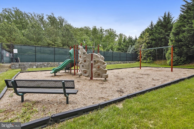 community jungle gym with fence and a yard