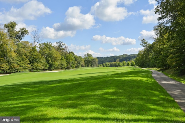 view of home's community featuring a yard and view of golf course