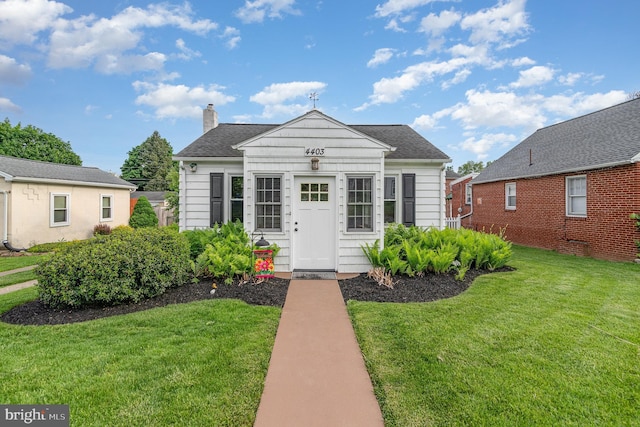4403 Lancaster St, Harrisburg, PA 17111 - bungalow-style house featuring a front yard, a chimney, roof with shingles, and an outbuilding