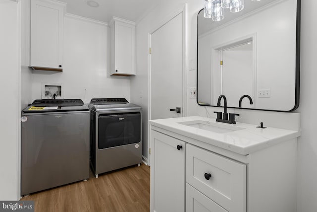 5235 Chalk Point Rd, West River, MD 20778 - laundry area with washer and dryer, crown molding, light wood finished floors, and cabinet space