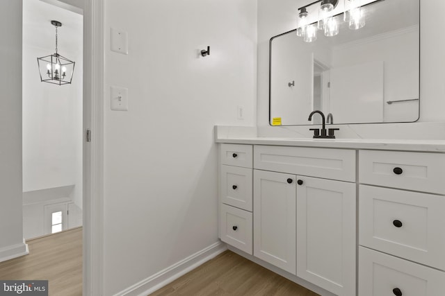 5235 Chalk Point Rd, West River, MD 20778 - bathroom featuring wood finished floors, baseboards, a chandelier, and vanity