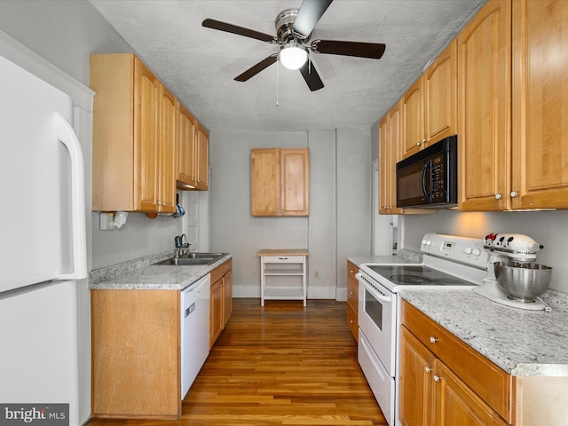 kitchen featuring wood finished floors, a ceiling fan, a sink, white appliances, and baseboards