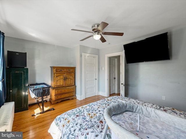 bedroom with wood finished floors, baseboards, and ceiling fan