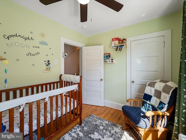 bedroom with wood finished floors, baseboards, and ceiling fan
