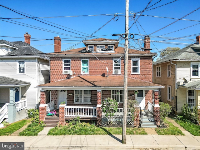 american foursquare style home featuring covered porch and brick siding
