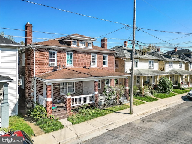 view of front of home featuring a chimney, cooling unit, a residential view, covered porch, and brick siding