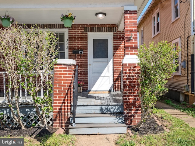 doorway to property featuring brick siding