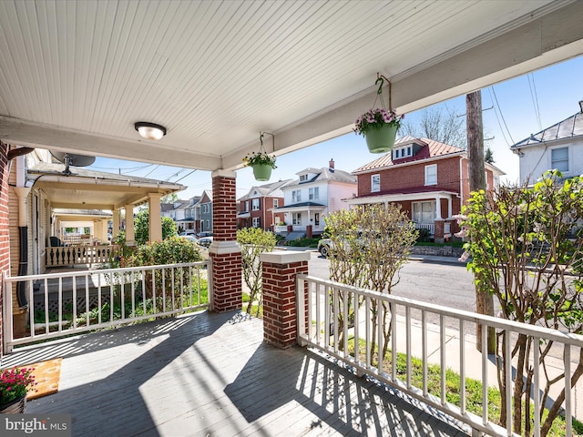 wooden terrace with a residential view and a porch