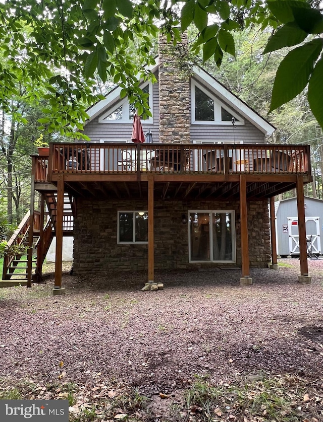 47 Holiday Dr, Albrightsville, PA 18210 - back of property with a storage shed, stone siding, a chimney, stairway, and an outbuilding