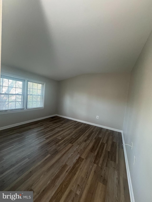 empty room with baseboards and dark wood finished floors