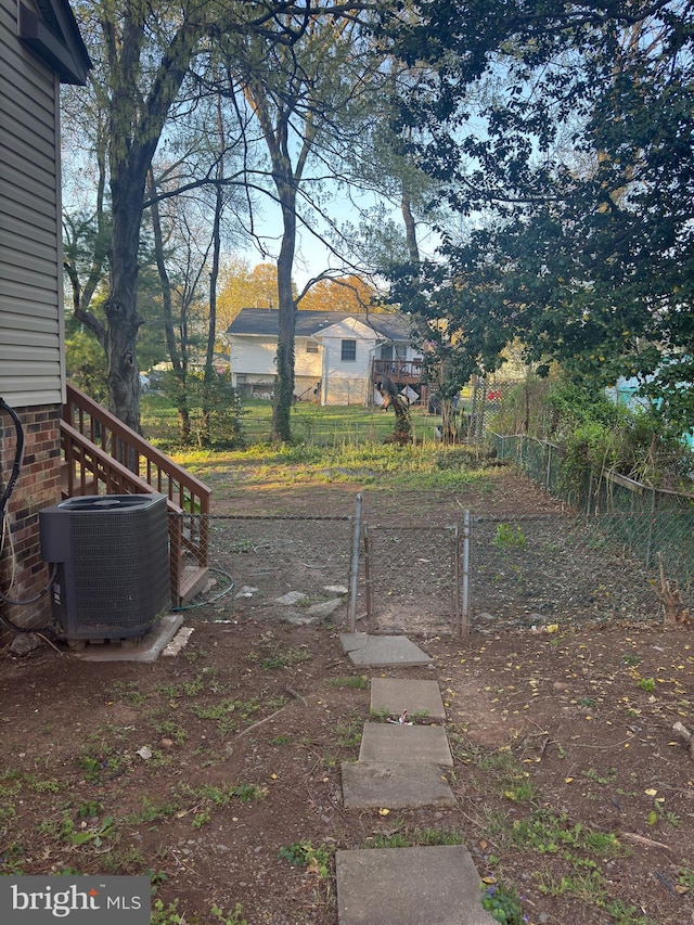 view of yard with central AC unit and fence