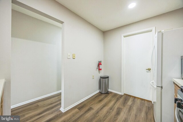 laundry room with baseboards, recessed lighting, and wood finished floors