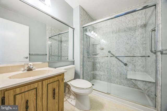 bathroom featuring vanity, toilet, and a shower stall