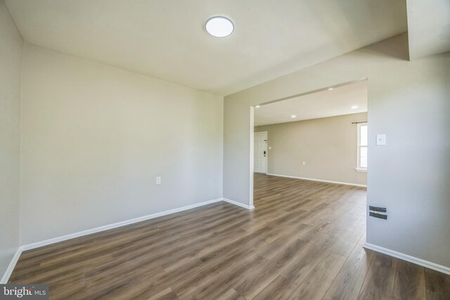 empty room with recessed lighting, baseboards, and wood finished floors