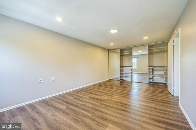 unfurnished bedroom with baseboards, recessed lighting, and wood finished floors