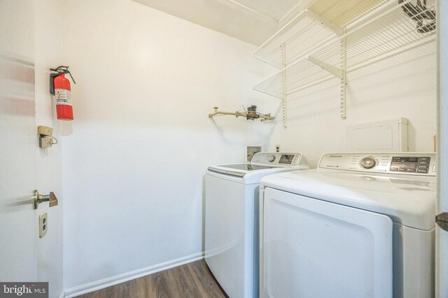 washroom with laundry area, dark wood-style flooring, independent washer and dryer, and baseboards