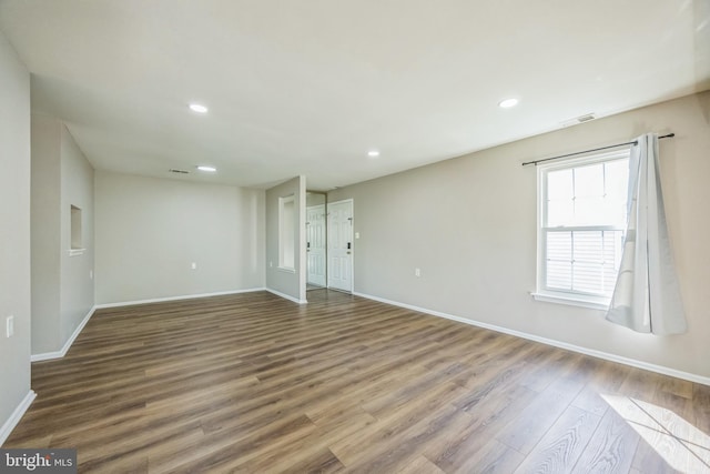 interior space with baseboards, recessed lighting, wood finished floors, and visible vents