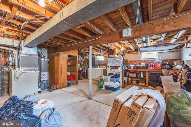 basement featuring washer and dryer, gas water heater, visible vents, and heating unit