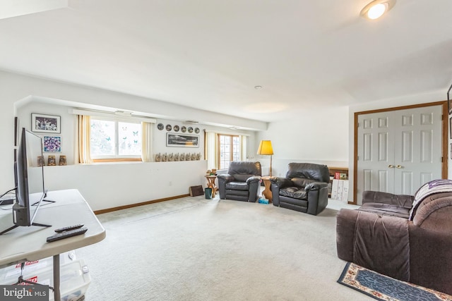 carpeted living area with baseboards
