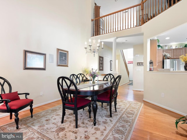154 N Landis Way N, Wilmington, DE 19803 - dining area with baseboards, light wood-style flooring, a high ceiling, and stairs