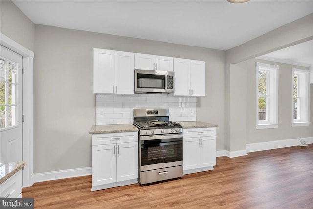 905 Cooper, Edgewater Park, NJ 08010 - kitchen featuring light wood-style floors, decorative backsplash, baseboards, and stainless steel appliances