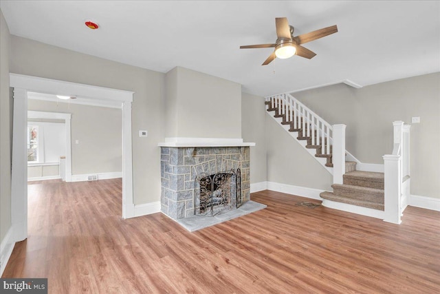 905 Cooper, Edgewater Park, NJ 08010 - unfurnished living room featuring baseboards, a fireplace with raised hearth, a ceiling fan, wood finished floors, and stairway