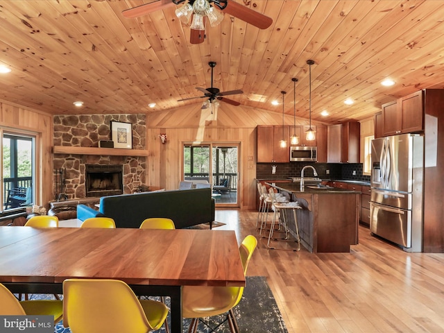 2201 Mill Gap Rd, Lost City, WV 26810 - dining space with lofted ceiling, a ceiling fan, wood walls, and light wood-style floors