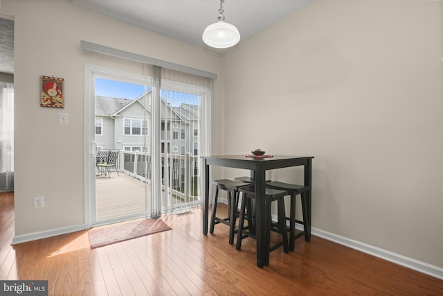 dining area featuring a wealth of natural light, baseboards, and hardwood / wood-style floors