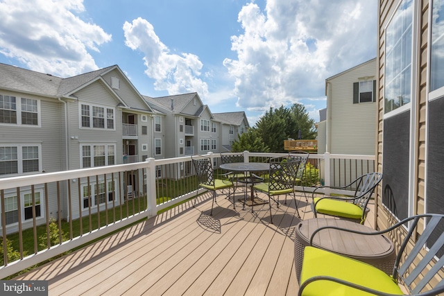 wooden deck with outdoor dining area and a residential view