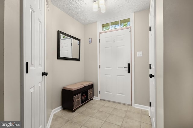 entryway with a textured ceiling and baseboards