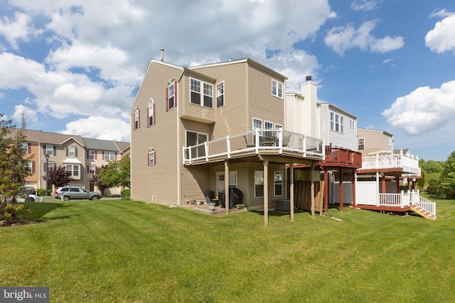 rear view of property featuring a yard and a wooden deck