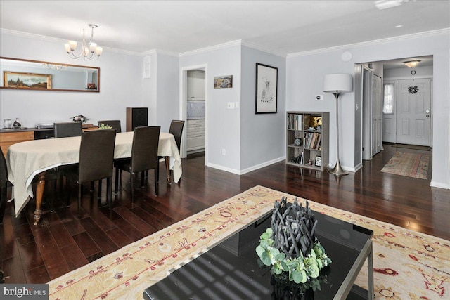 dining room with a chandelier, wood finished floors, crown molding, and baseboards