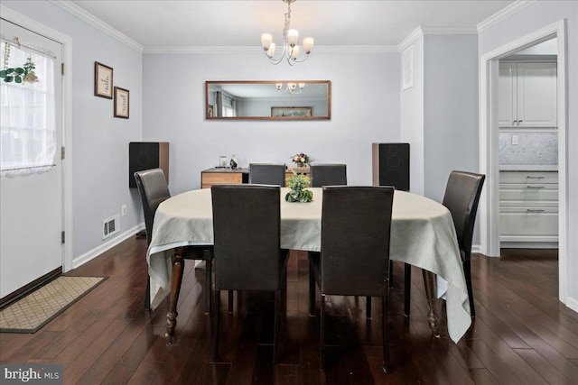 dining space with ornamental molding, a chandelier, dark wood-type flooring, and visible vents