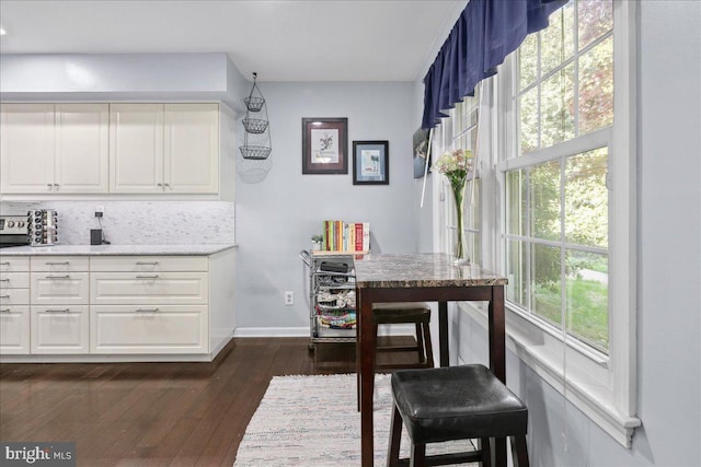 dining room featuring baseboards and dark wood-style flooring