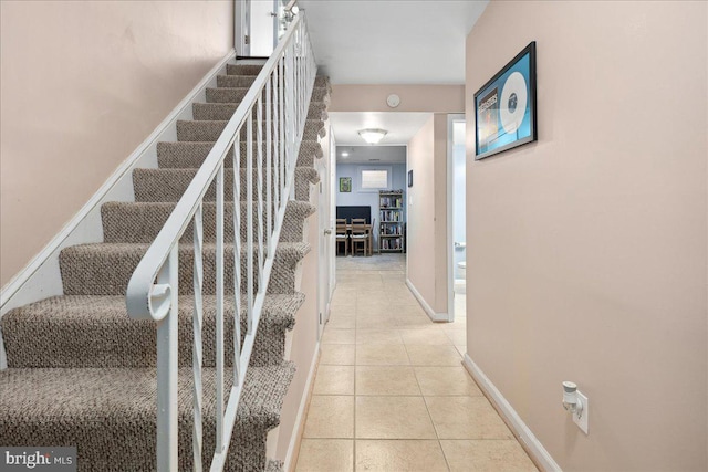 stairs with tile patterned floors and baseboards