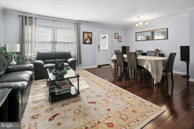 living room with baseboards, dark wood-style floors, a chandelier, and ornamental molding