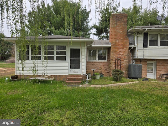 938 Church Hill Rd, Milford, DE 19963 - view of front of home featuring central AC, entry steps, a front yard, brick siding, and a chimney